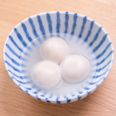 Tang yuan, tangyuan, yuanxiao in a small bowl. Delicious asian traditional festive food rice dumpling balls with stuffed fillings for Chinese Lantern Festival, close up.