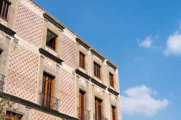Fototapeta na wymiar Detail with windows in colonial house. Blue sky in Mexico city. Travel photo. Wallpaper or background.
