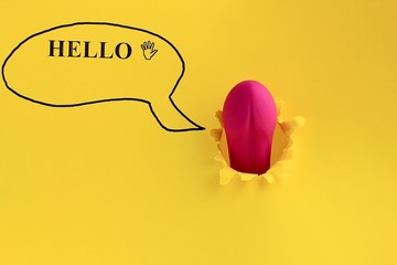 Sex toy for adult, dildo vibrator looking through a hole in the yellow paper with text hello. Funny concept of sex, pleasure, present. Copy space.