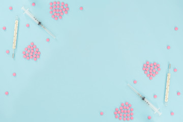 Hearts made of pink pills, thermometer, syringe on light blue background. Seasonal diseases....