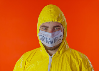 Man in yellow chemical protection suit and face protective mask coronavirus. Without glasses.