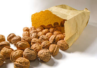 Still life with a paper bag with spilled walnuts on a plane.