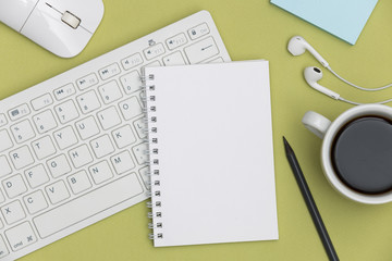 Blank spiral notebook and pencil on green background. Top view with copy space for input the text.