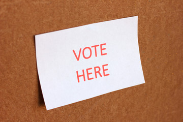 Vote HERE sign. The concept of voting, making choices. Presidential and parliamentary elections. Calling for voting, democracy.
