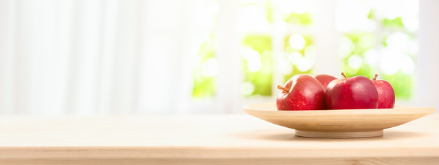 Fresh Ripe red apples in bowl on wooden table