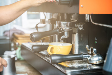 Prepares espresso machine brewing a coffee in coffee shop