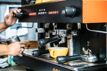 Prepares espresso machine brewing a coffee in coffee shop