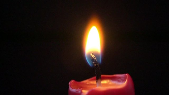 Slow motion of a candle's growing flame after having been lit up