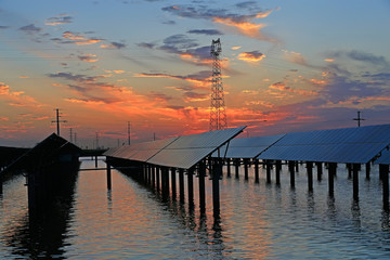 Solar photovoltaic panels in the water, in the sunset sky background