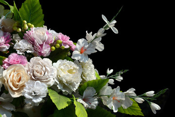 Bouquet of artifitial white and pink flowers on black background, space for copy