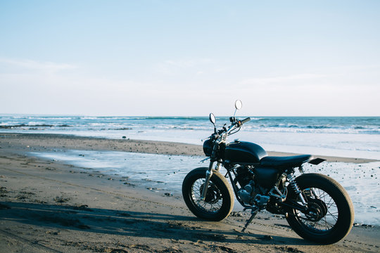 Modern motorbike parked at sunny beach