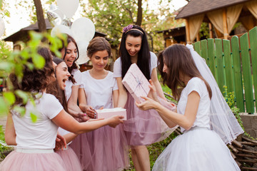 Pretty bride opens present from girlfriends at hen party