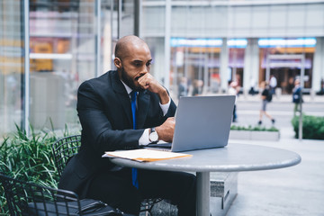 Stressed African American businessman working on laptop