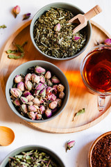 Composition with different kinds of tea: green, black and herbal tea, with fruit and flowers. Antioxidant, anti stress. Wooden elements, white background, flat lay, top view, close up, copy space
