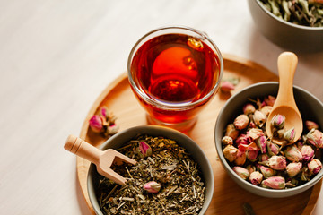 Composition with different kinds of tea: green, black and herbal tea, with fruit and flowers. Natural organic drink, antioxidant and anti stress. Wooden elements, white background, copy space for text