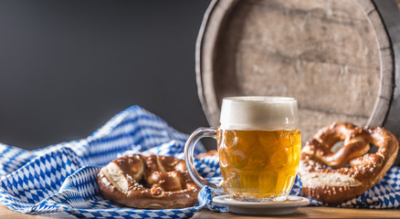 Oktoberfest beer with pretzel wooden barrel and blue tablecloth