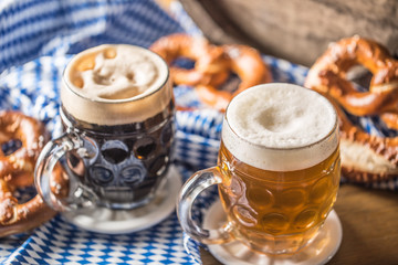Oktoberfest two beer with pretzel wooden barrel and blue tablecloth