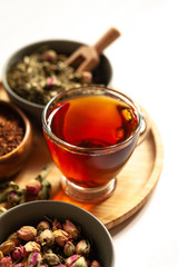 Composition with different kinds of tea: green, black and herbal tea, with fruits and flowers. Natural organic drink, antioxidant and anti stress. Wooden elements, white background.