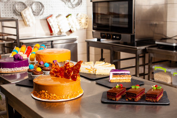 Cakes and pastry on a metal table at confectionery shop.