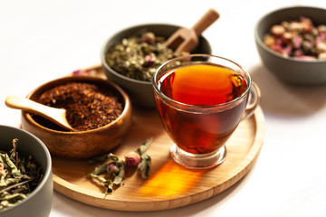 Composition with different kinds of tea: green, black and herbal tea, with fruit and flowers. Natural organic drink, antioxidant and anti stress. Wooden elements, white background