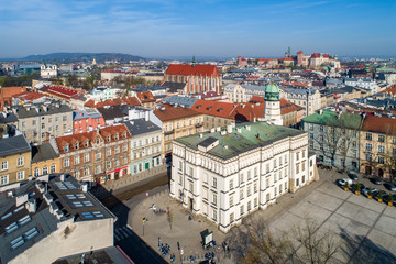 Fototapeta na wymiar Old town hall of Kazimierz town, then the Jewish district of Krakow, Poland, situated at Wolnica Square. Wawel Castle, St Catherine church, Skalka church and monastery in the background. Aerial view