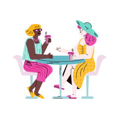 Two female friends sitting at table drinking take out coffee and talking