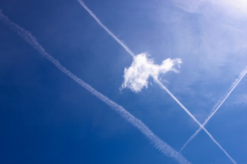 cloud and airplane tracks in the summer clear blue sky