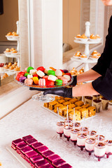 Luxury cakes and french macaroons on dessert table in restaurant