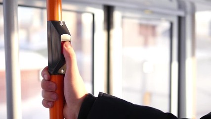 Girl presses bus stop bell on the bus in slow motion. Red stop transport button
