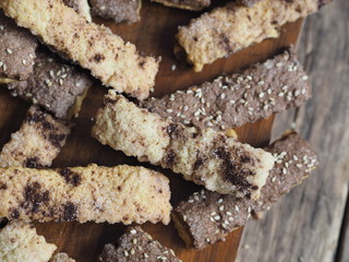 Homemade shortbread puff pastry chocolate chip cookies on a cutting kitchen board. Wooden ancient table. View from above.