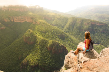 Naklejka premium Female Hiker Sitting on Mountain Rock in Africa