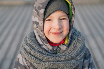 A sincere smile of child. Seven years old boy in good mood, positive emotions. Cold season day.