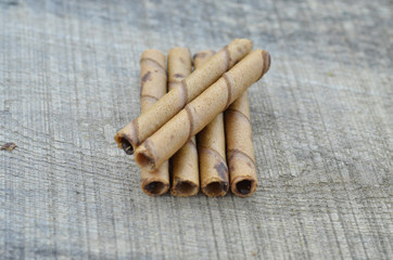Chocolate waffle roll sticks on wooden background