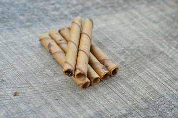 Chocolate waffle roll sticks on wooden background
