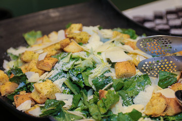 Green salad with fried tofu in a black bowl. Marinated Asian tofu salad at restaurant buffet.