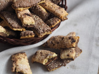 Homemade sandwich puff pastry chocolate cookies in a wicker natural plate from the vine. Wooden ancient table. View from above.