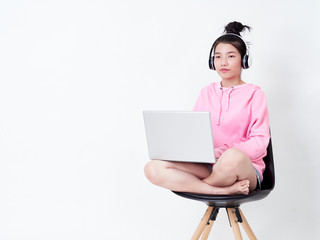 Cheerful girl using laptop sitting on chair.