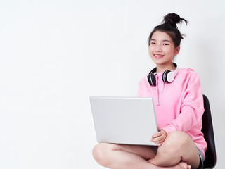 Cheerful girl using laptop sitting on chair.