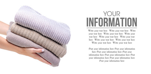 Stack folded sweater clothing hand holding on white background isolation, space for text