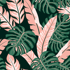 Abstract seamless tropical pattern with green and pink leaves and plants on a dark background. Trendy summer Hawaii print.  Floral pattern. Printing with in hand drawn style. Jungle leaves.