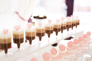 Delicious sweets on wedding candy buffet with desserts, cupcakes