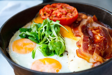 Grilled toasts served with beans, scrumbled eggs and sausage for an English breakfast.