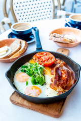 Grilled toasts served with beans, scrumbled eggs and sausage for an English breakfast.