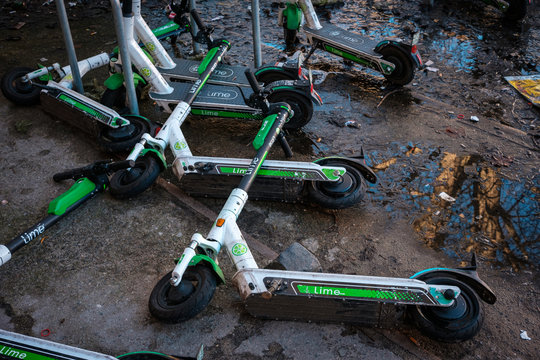 Electronic scooter or E-Scooter of the company Lime laying on dirty floor in Berlin, Germany - February, 2020