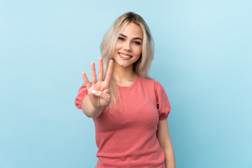 Teenager girl over isolated blue background happy and counting four with fingers