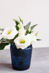 White flowers in classic blue glass. Lisianthus. Eustoma