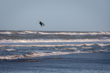 Kite surfing in wintertime on the North Sea near Hoek van Holland in the Netherlands, on a cold and windy day 