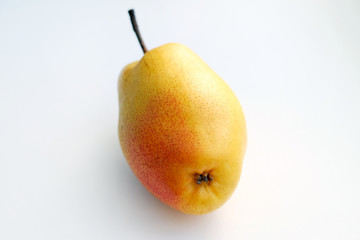 Yellow pear with a red side on a white background. Ripe hard pear in the winter season.