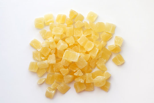 Dried pineapple cubes on a white background. Candied pineapple top view. Sweet dried pineapples in sugar syrup.