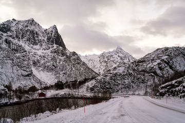 Mountain landscape and snowy road. Lofoten islands winter road trip photo.